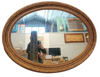 Grand miroir ovale en bois et stuc doré