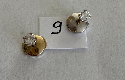 pair of diamond stud earrings on a white background with the letter g in the middle