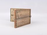 an old book with writing on it sitting on top of a white surface