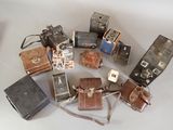 a lot of old cameras sitting on a table
