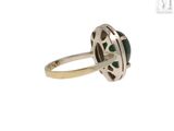 a close up of a ring with a green stone in it