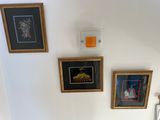 a picture of a bathroom with a toilet and pictures on the wall