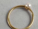 a close up of a gold ring with a pearl on it