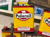 three cans of oil sitting on a stand in front of a store