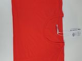 La chemise est rouge et porte une étiquette blanche.