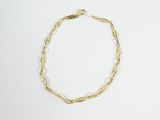 a close up of a gold bracelet on a white surface