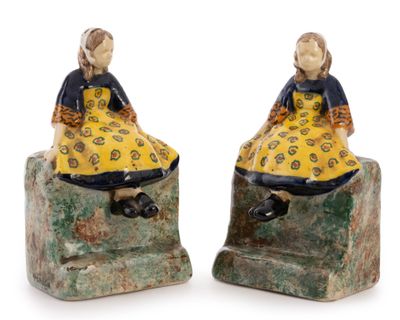pair of ceramic figurines of a girl and boy sitting on a rock