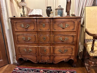 a wooden dresser with many drawers and a rug on the floor