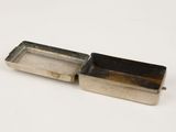 an old silver box with a lid on a white surface