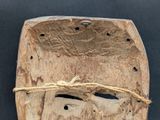 a wooden mask with a rope wrapped around it