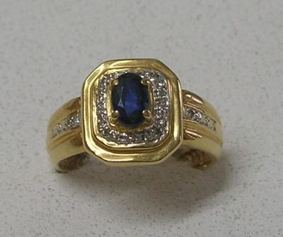 une image d'une bague en or avec un saphir et des diamants