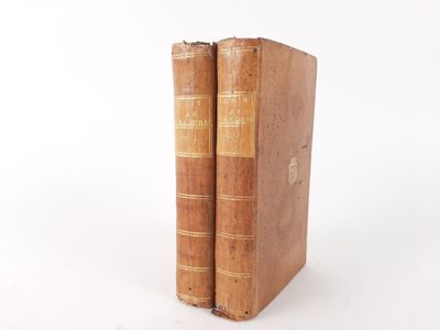 two old books sitting on top of each other on a white surface