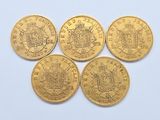 four gold sovereigns of different sizes and shapes