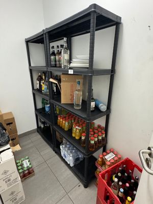 une étagère avec des bouteilles et des boîtes de conserves dans une pièce