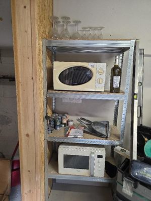 un micro-ondes et un four à micro-ondes posés sur une étagère dans une pièce