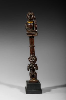 une image représentant une statue en bois d'un homme avec un oiseau sur la tête