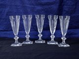 four clear glass goblets on a black background