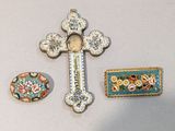 une croix, une broche et une broche posées sur une table