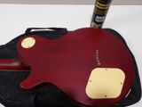 a red electric guitar sitting on top of a black bag