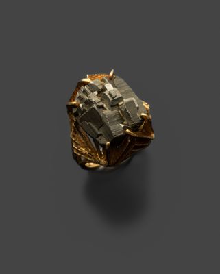 gros plan d'une bague en or avec une pierre noire