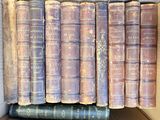 several old books are stacked on top of each other in a box