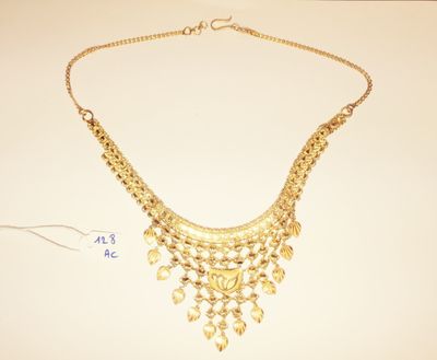 a close up of a gold necklace on a white surface