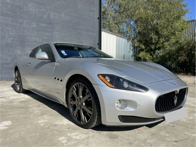 a silver sports car parked in front of a building