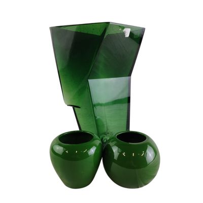 deux vases verts posés l'un à côté de l'autre sur une surface blanche