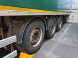 a green and yellow semi truck parked on the side of the road