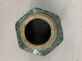 a green vase that is sitting on a white surface