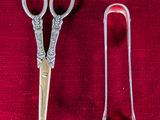 deux paires de ciseaux posées l'une à côté de l'autre sur un tissu rouge