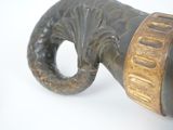 a black and gold vase on a white surface