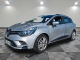 une voiture argentée est garée dans une pièce au sol en damier