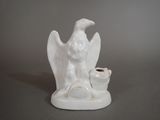 a white statue of a bird with a pot in it