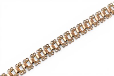 a close up of a gold bracelet on a white background
