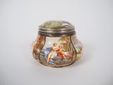 a small glass jar with a picture of a woman on it