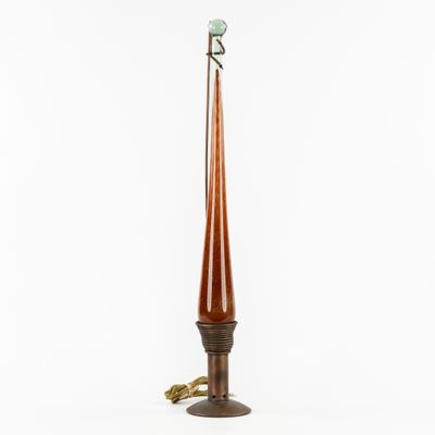 une grande lampe en bois surmontée d'un abat-jour en verre vert