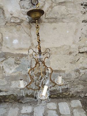 a chandelier hanging from a stone wall in a room