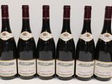 six bouteilles de vin sont alignées sur une table