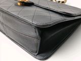 a close up of a black chanel bag on a white background