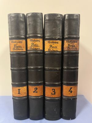 cinq vieux livres sont alignés sur une surface bleue
