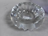 a glass ashtray and a purple candle holder on a table
