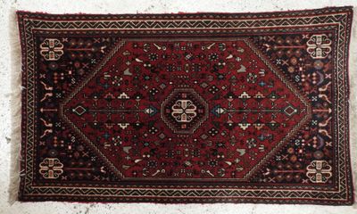un tapis rouge et noir accroché à un mur blanc