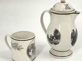 une cafetière blanche et noire à côté d'une tasse à café
