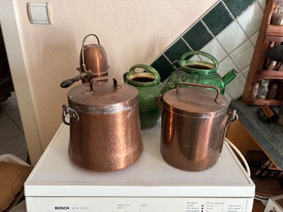 pots and pans sitting on top of a washing machine in a kitchen