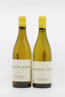 deux bouteilles de vin posées l'une à côté de l'autre sur une surface blanche