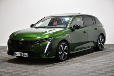 La voiture verte est garée sur un sol à damier dans une pièce.