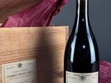 une bouteille de vin posée à côté d'une caisse en bois