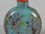 a small glass bottle with a red cap on it