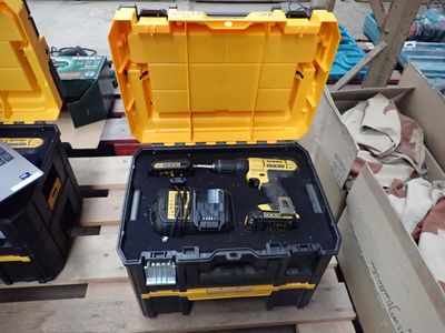 deux outils jaunes et noirs dans une boîte posée sur une palette